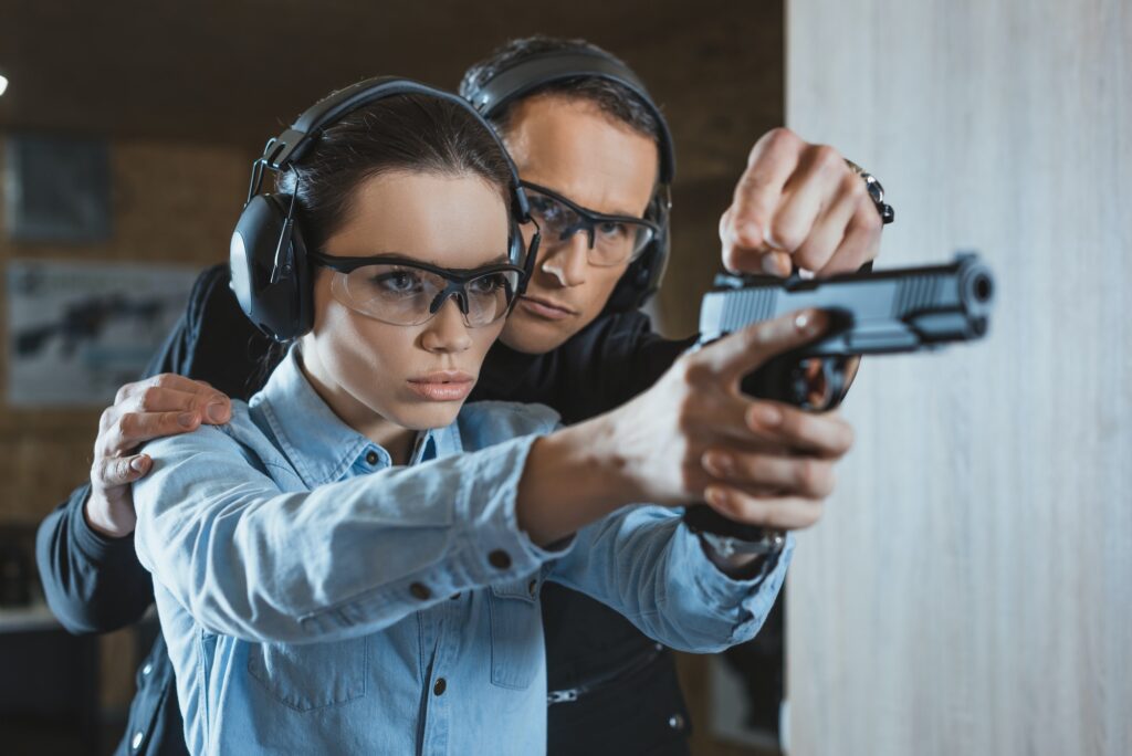 instructor helping customer in shooting gallery